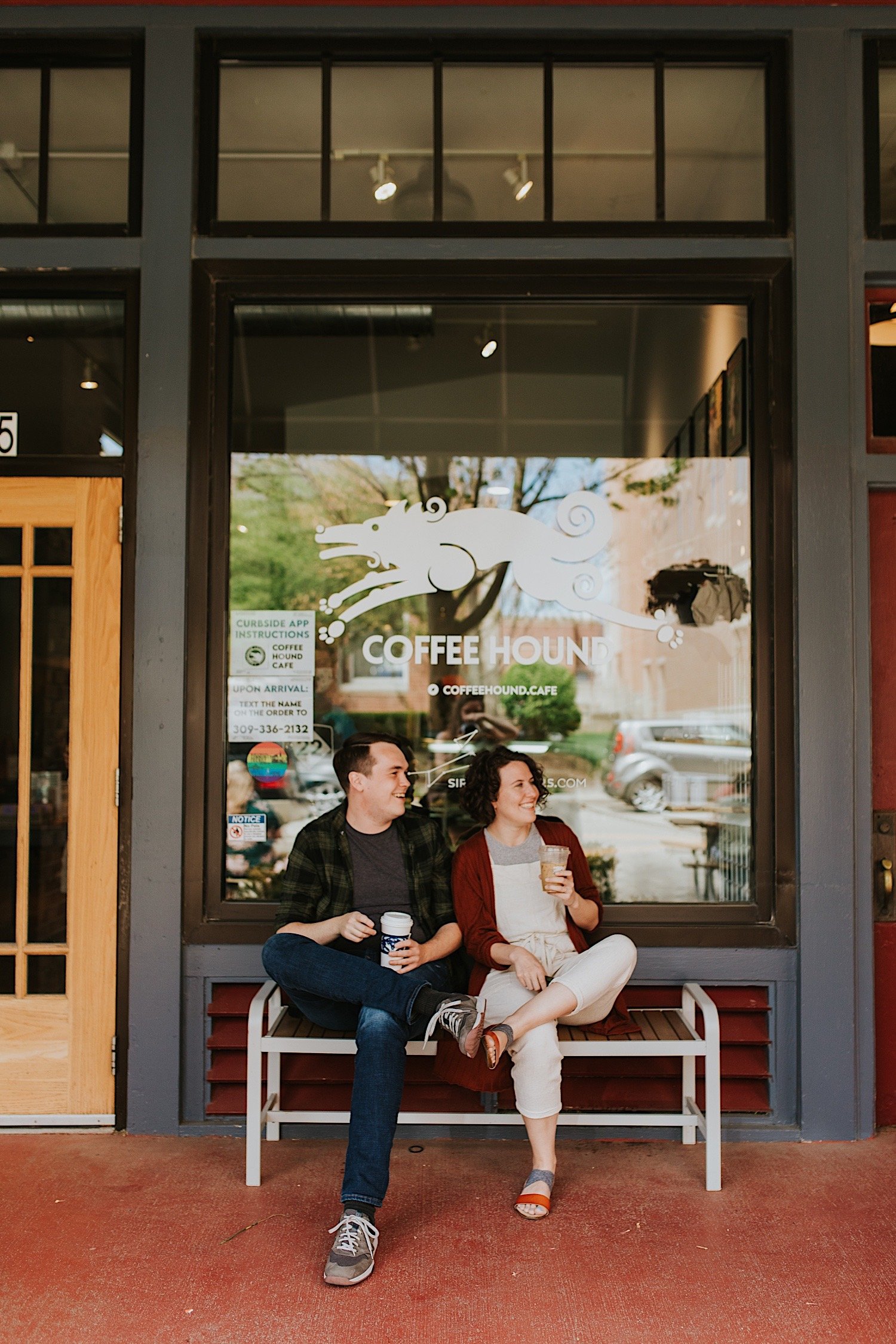 Engaged couple sits on a bench outside the Normal Illinois Coffee Hound