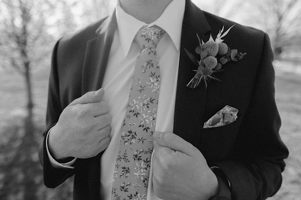 Black and white photo of a close up of a grooms suit and tie