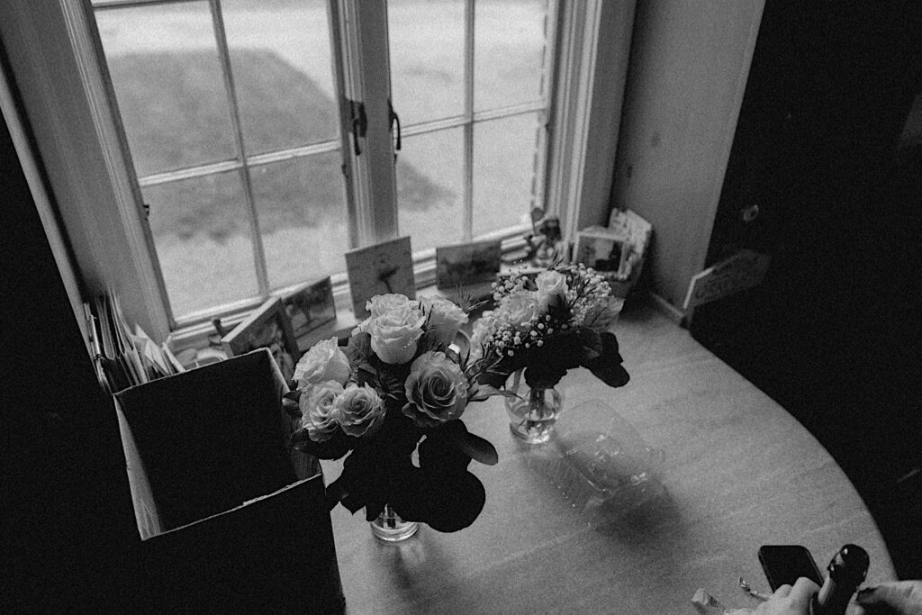 Black and white photo of flowers in vases on a table