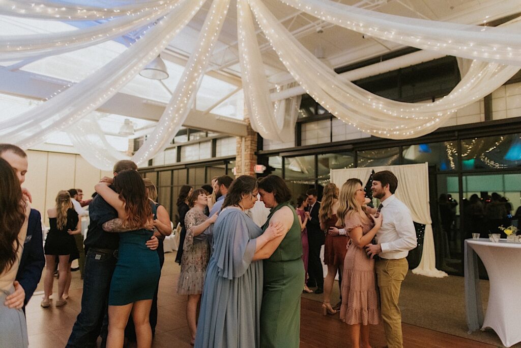 Guests of a wedding reception at Erin's Pavilion all slow dance with one another