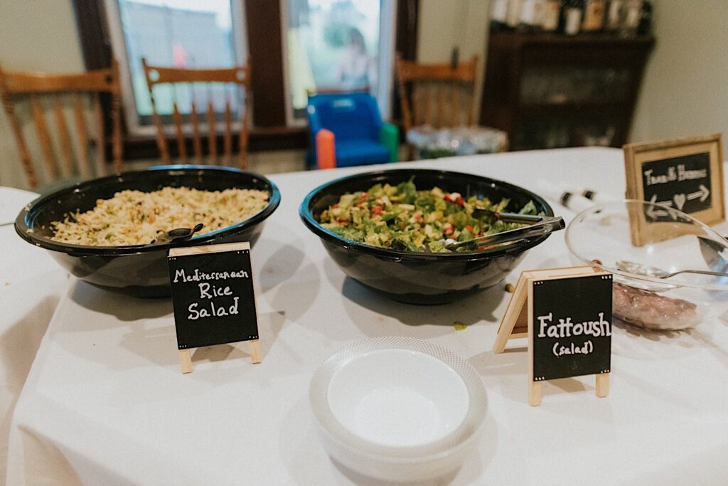 Mediterranean Rice Salad and Fattoush dishes are set up on a table for guests of a wedding to take from