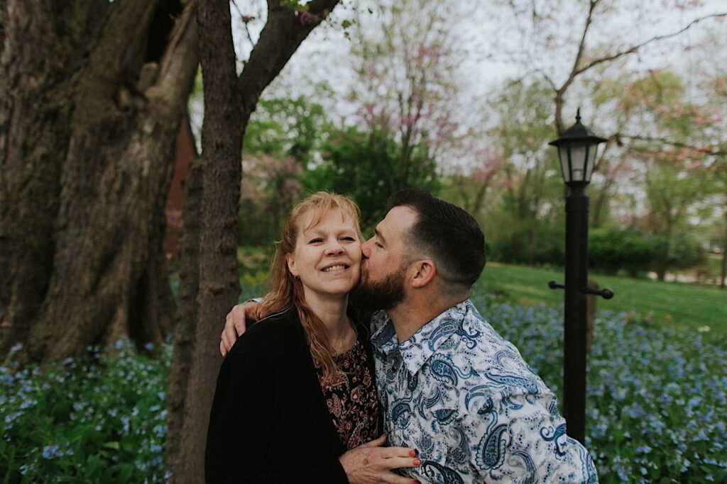 A man kisses his mother on her cheek in his backyard after his wedding ceremony