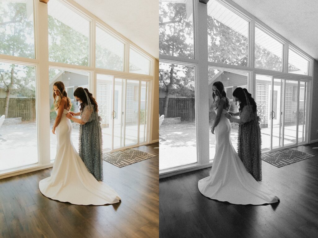 Two photos side by side, they are the same photo but the right is in black and white, a bride stands in front of a large wall of windows as her mother stand behind her buttoning up her wedding dress