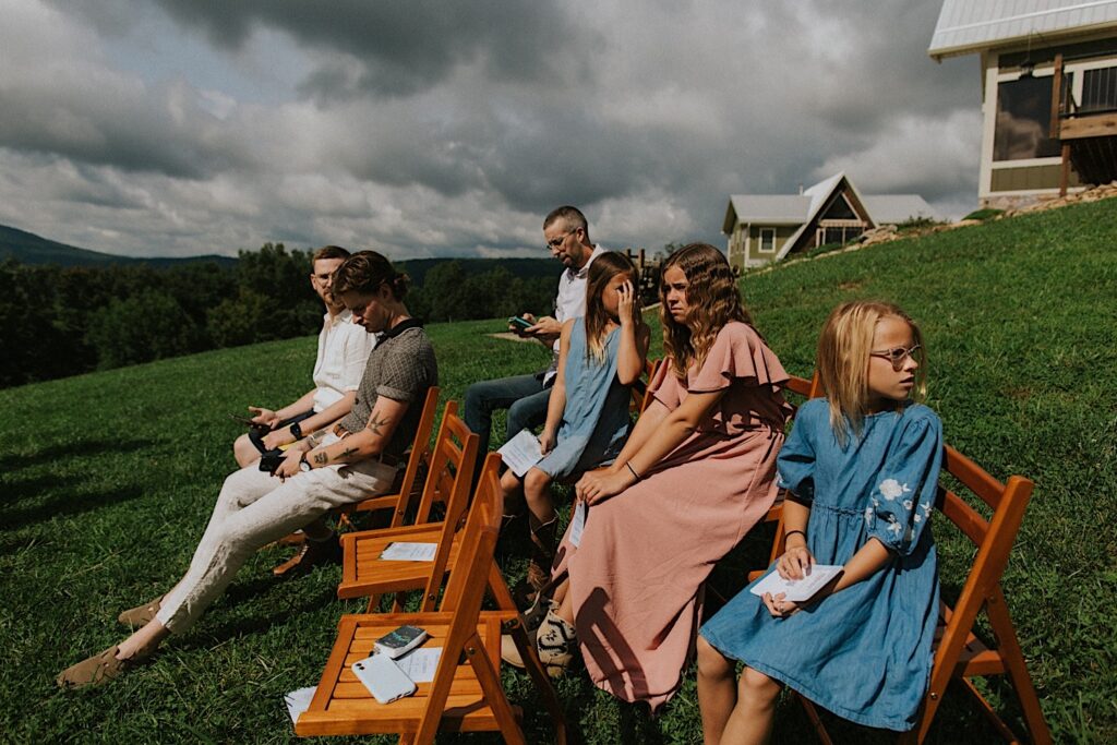 Guests of an intimate destination wedding in Tennessee sit outdoors as they wait for the wedding ceremony to begin