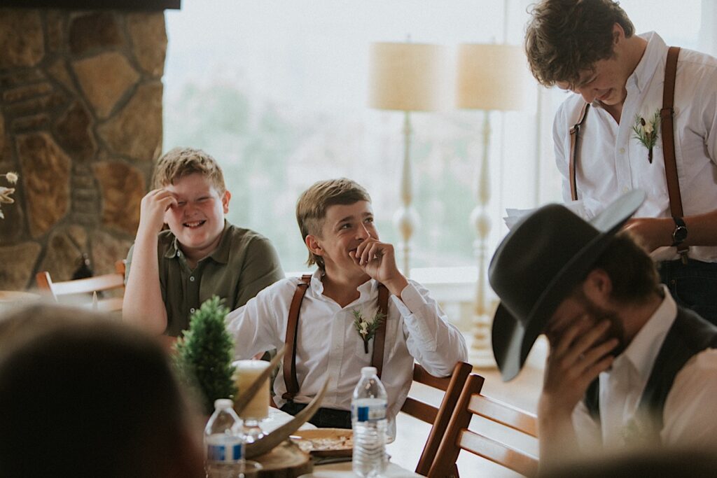 Guests laugh as a groomsmen stands and gives a speech during an intimate destination wedding in Tennessee
