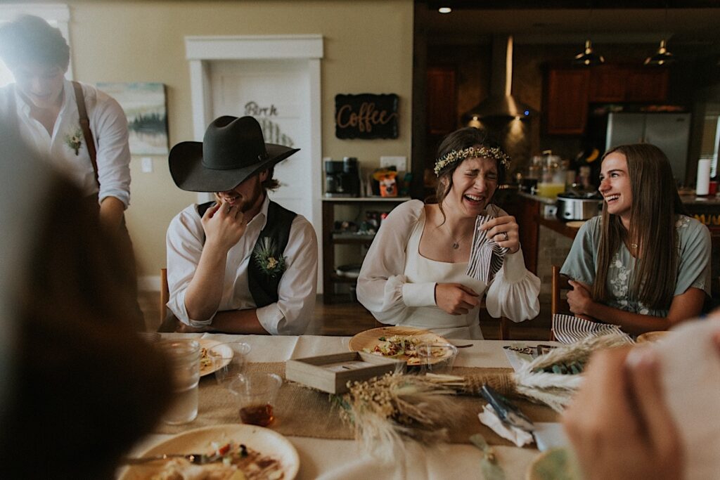 A bride and groom cry from laughing so hard during a speech at the reception of their intimate destination wedding in Tennessee