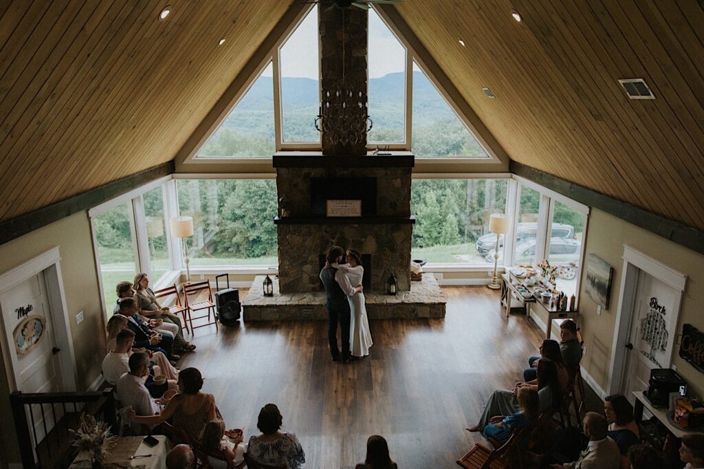 A bride and groom dance in the center of a living room as guests around them watch during their intimate destination wedding in Tennessee