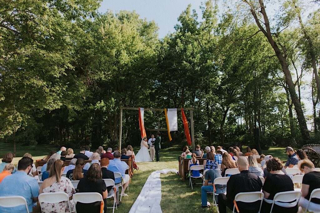 A wedding ceremony takes place at the outdoor space at the Clayville Historic Site
