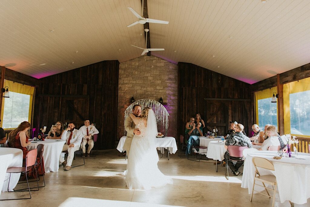 A bride dances with her father during her indoor wedding reception at the Clayville Historic Site
