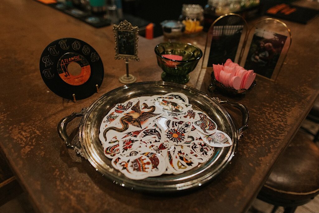 A dish of temporary tattoos sits on a table for guests of a wedding