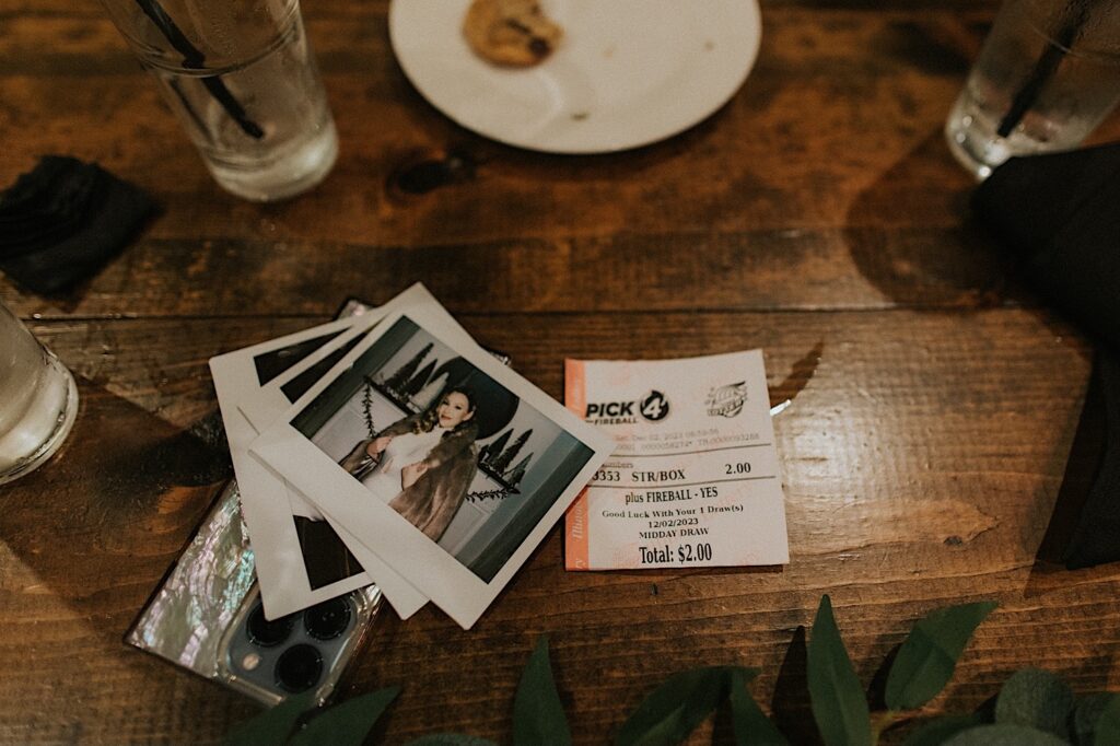A photo of polaroid photos on a table next to a lottery ticket