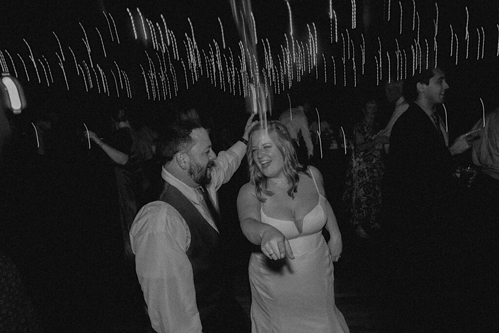 Black and white photo of a bride and groom dancing together during their wedding reception at Trailside Event Center