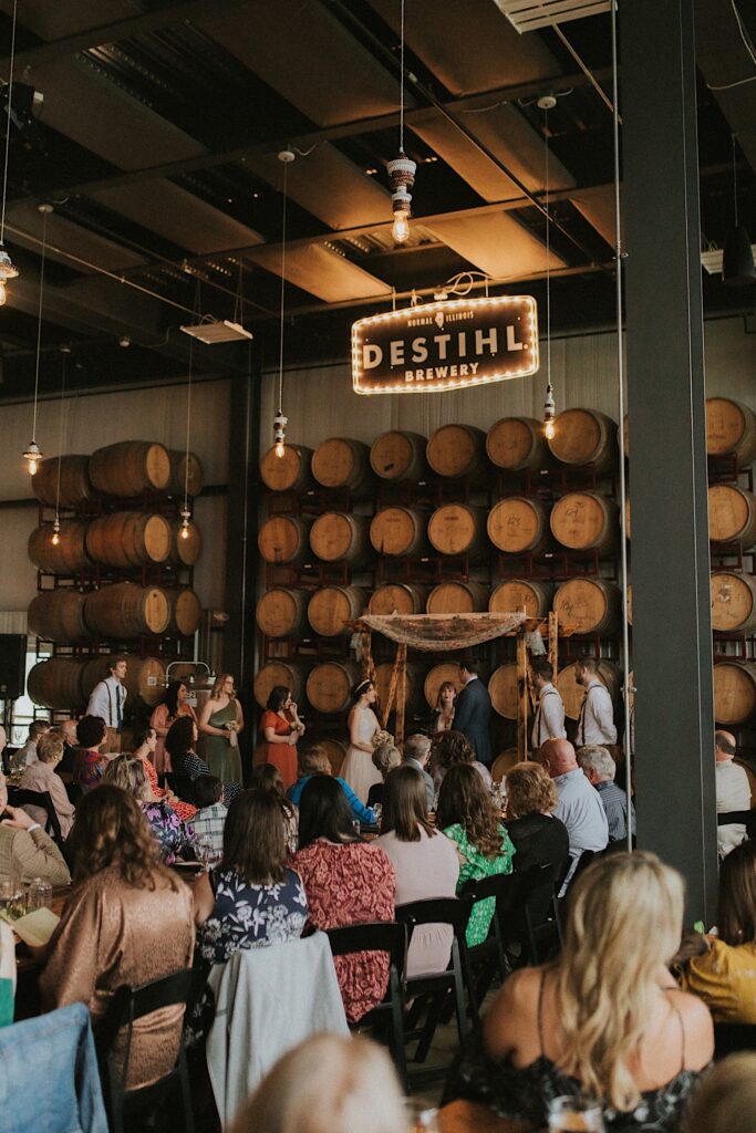 A wedding ceremony takes place inside of The Barrel Room at the Destihl Brewery