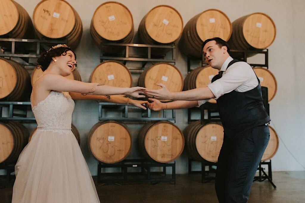 A bride and groom dance together during their indoor reception at their wedding venue, The Barrel Room at the Destihl Brewery