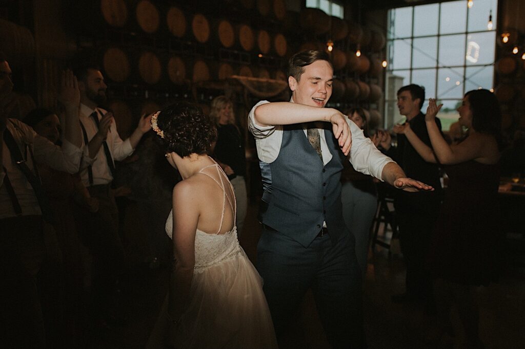 A bride and groom dance with guests of their wedding during their indoor reception at the Destihl Brewery
