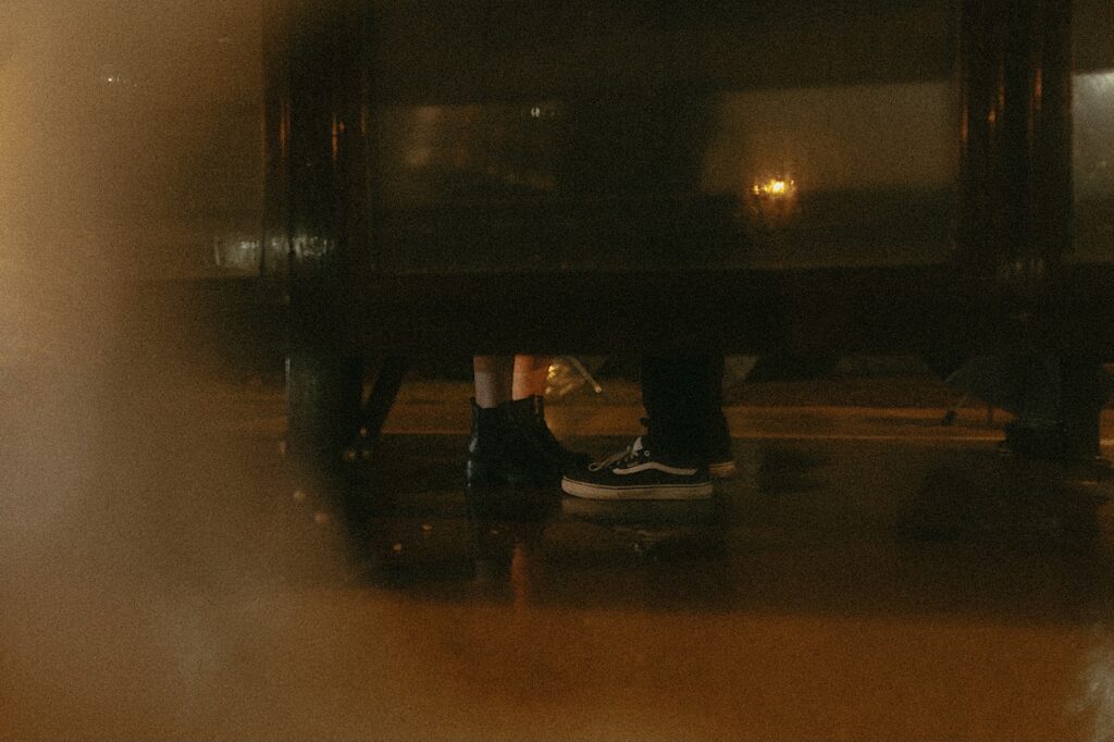 Springfield couples photographer captures couples feet standing in the rain under a bus stop in the rain in downtown Springfield, Illinois. 