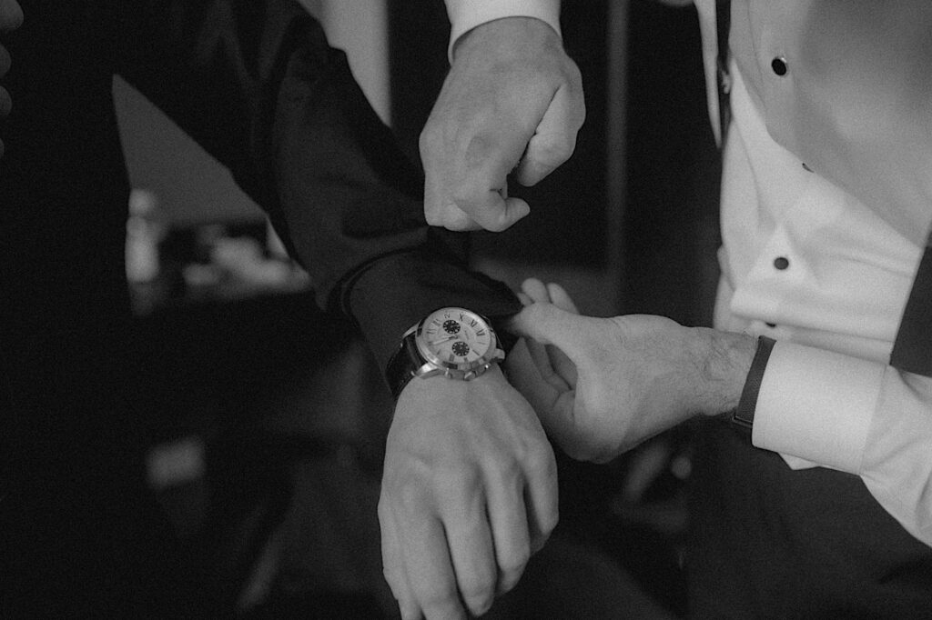 Chicagoland wedding photographer captures Groomsmen's hands helping groom put on cufflinks. 