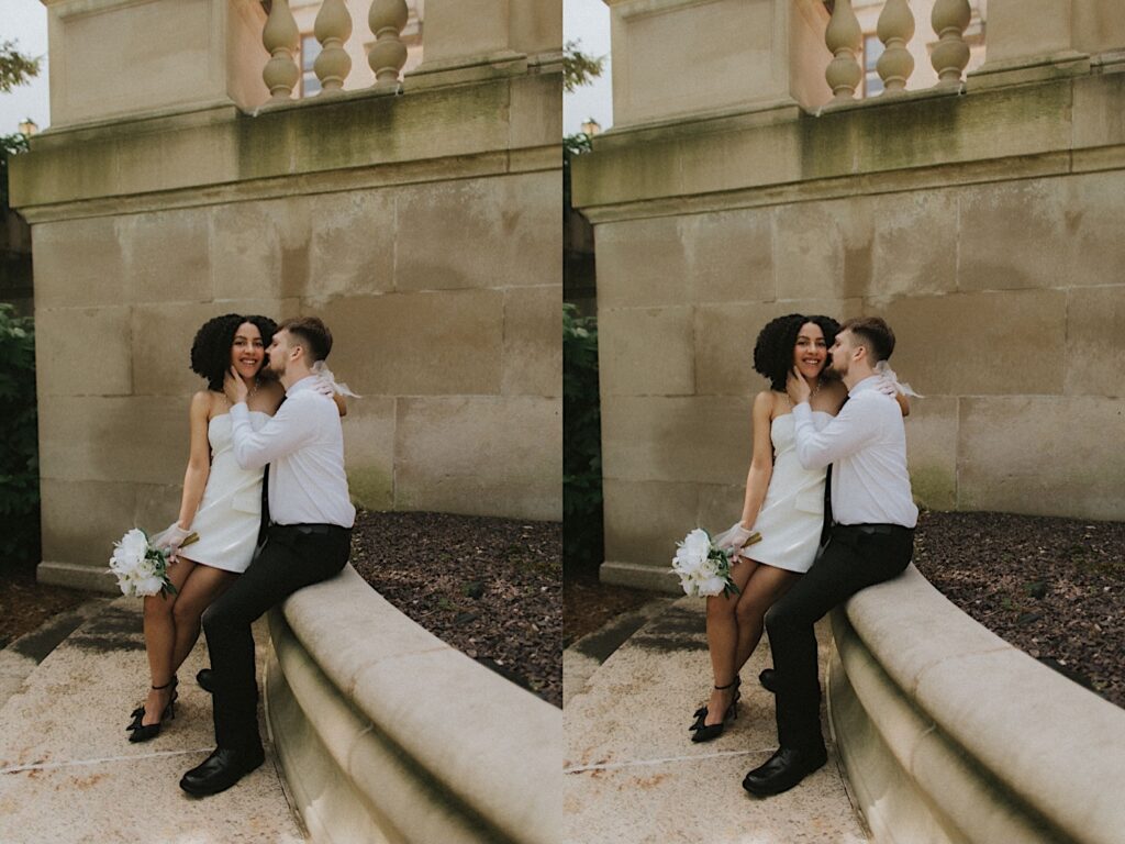 Bride sits on Groom's lap as he kisses her on a ledge outside the Springfield Courthouse for elopement portraits. 