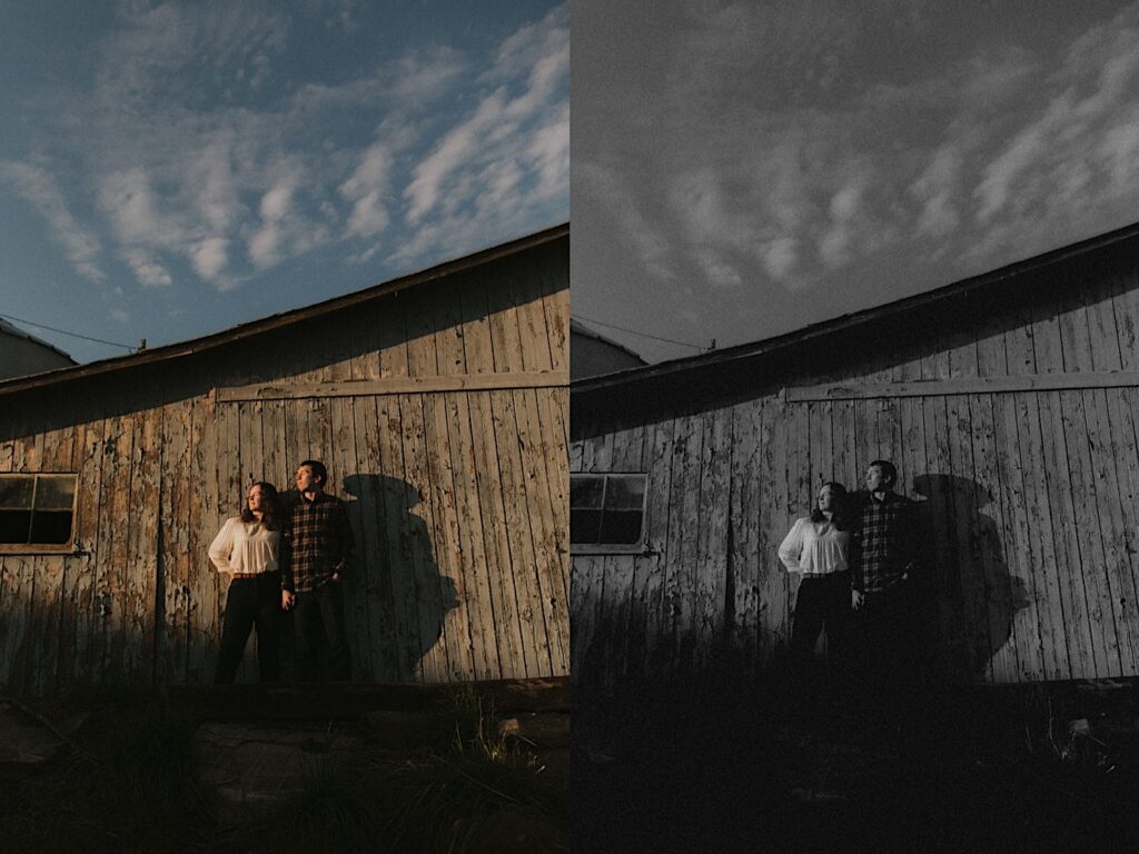 couple stands next to a wood shed with beautiful blue skies behind them on a farm in Springfield Illinois for engagement photoshoot. 