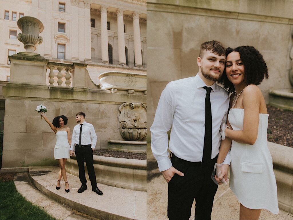 Bride in a short white dress and groom in a white shirt and black tie stand together holding hands and the bride puts her bouquet in the air with the Springfield Courthouse in the background. 