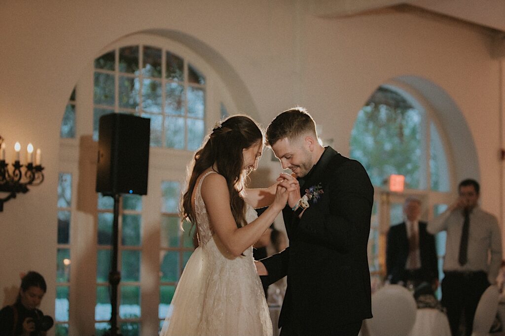 Bride and Groom look at their feet as they perform their first dance in the Ravisloe Country Club reception hall. 