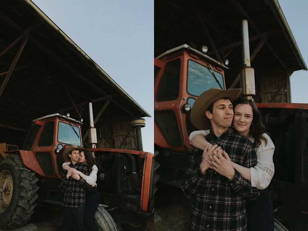 Girl in white shirt hugs man in cowboy hat from behind in front of farming tractor in Springfield Illinois for engagement photoshoot. 