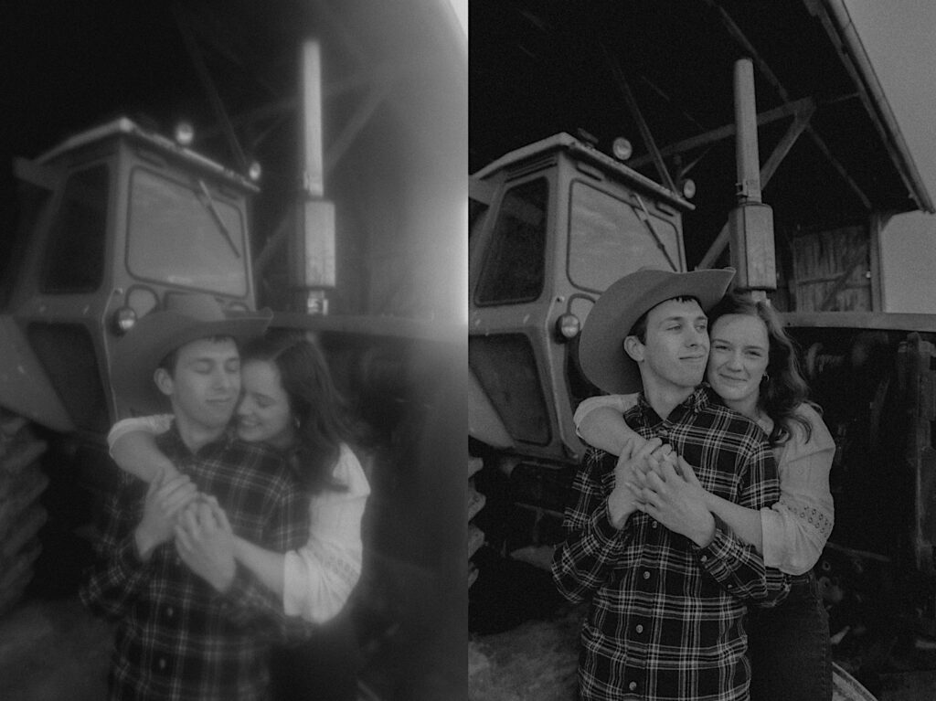 Black and White photograph of girl in white shirt hugs man in cowboy hat from behind in front of farming tractor in Springfield Illinois for engagement photoshoot. 