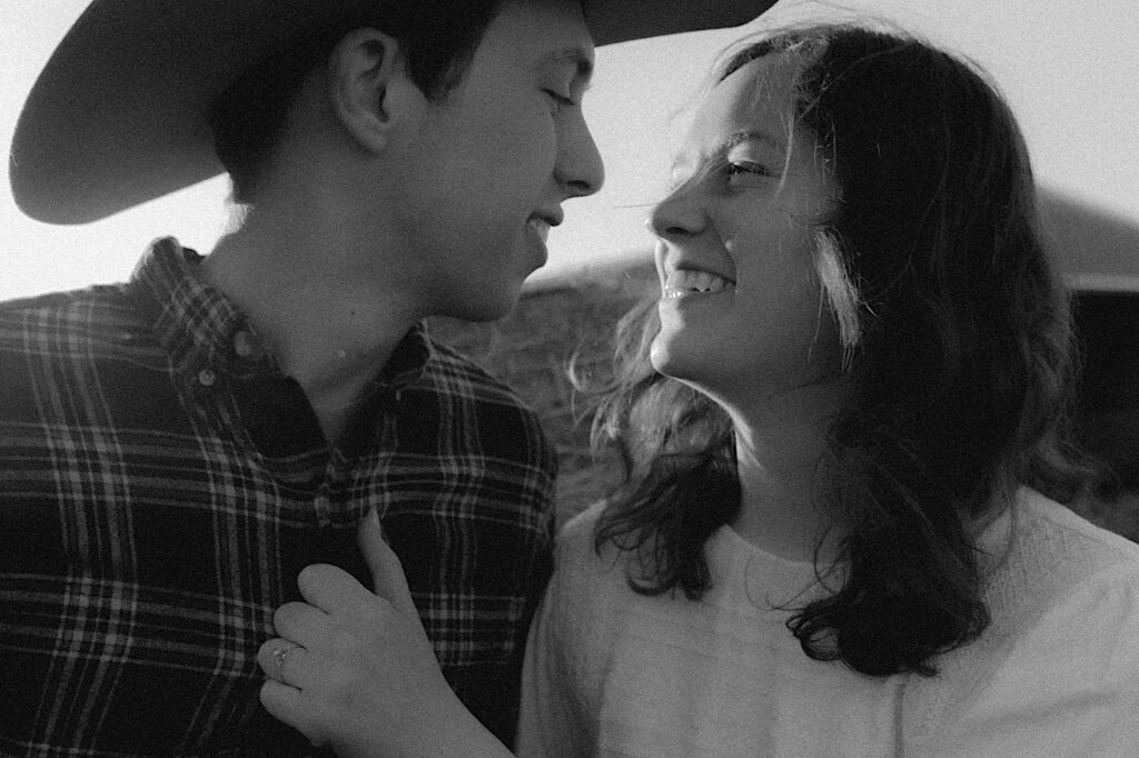 Black and white photo of couple looking at each other during engagement photo session on a farm in Springfield, Illinois. 