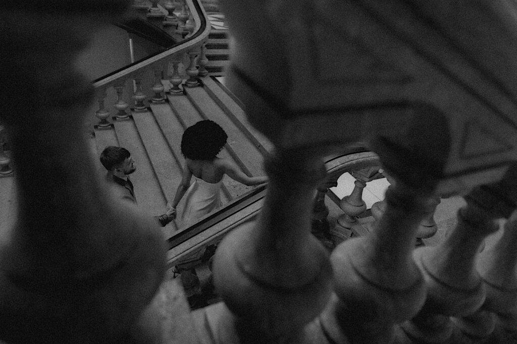 Springfield elopement photographer captures bride and groom through stair banisters as they walk up the steps. 