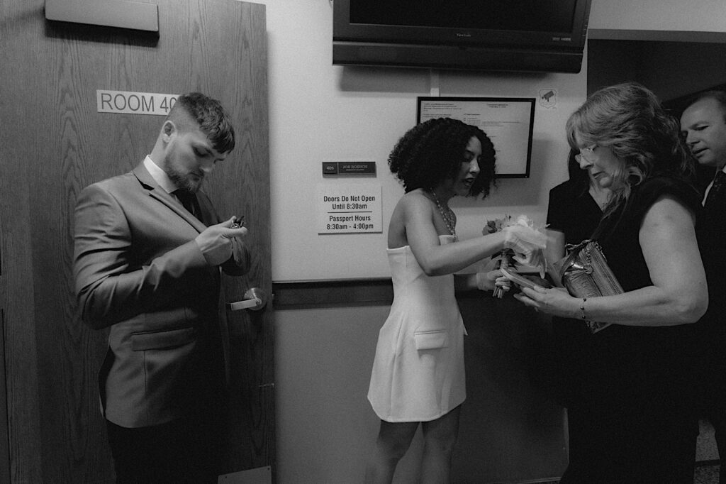 Bride gives her phone to her mom before elopement ceremony in the Springfield Courthouse. 