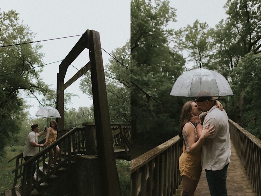 Couple walks up wooden steps onto a bridge in a forest holding a clear umbrella as they hike through a camping ground in Lincoln, Illinois. 