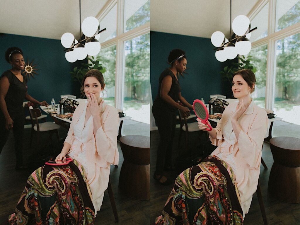 Bride gets emotional after looking at herself in a hand mirror and seeing her makeup for the first time before wedding ceremony in central Illinois. 