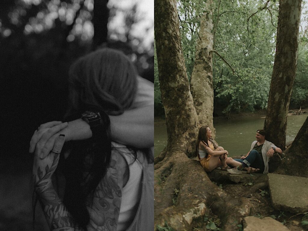 Couple sits underneath a tree near a stream facing each other and smiling  for camping style engagement photos in Lincoln, Illinois. 