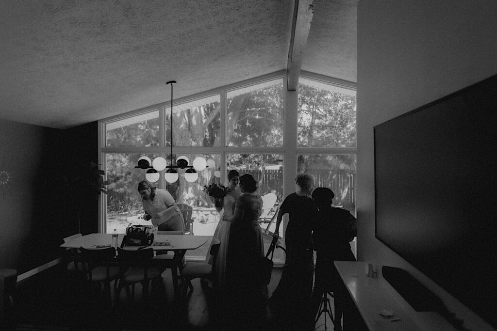 Central Illinois wedding photographer captures bride and women in her family walking around room while getting ready for wedding ceremony. 