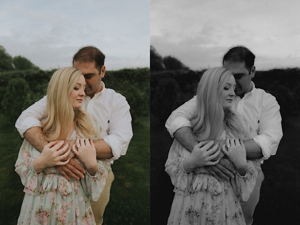 Woman stands as her fiance holds her from behind with beautiful greenery in the background. 