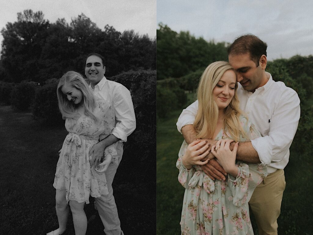 Woman stands as her fiance holds her from behind with beautiful greenery in the background. 