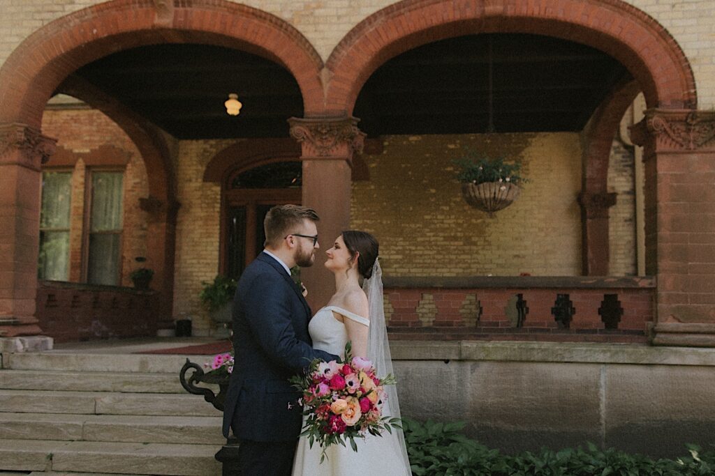 Bride and Groom hold each other and look into each other's eyes outside of Reality on Monroe wedding venue. 