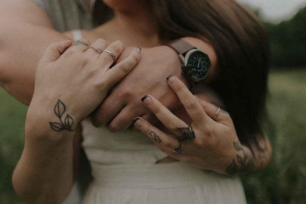 Lincoln, Illinois Engagement photographer captures details of couple's hands including their tattooed fingers, rings and a vintage watch. 