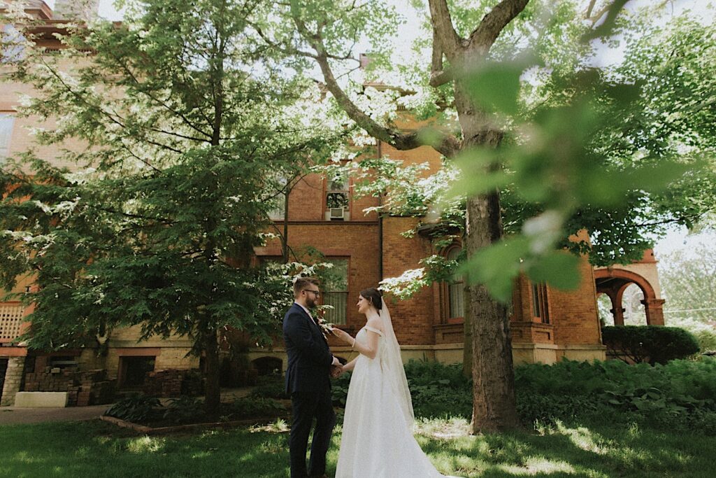 Bride reads her vows as she holds groom's hands in front of Reality on Monroe wedding venue during private vows. 