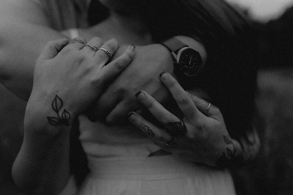 Lincoln, Illinois Engagement photographer captures details of couple's hands including their tattooed fingers, rings and a vintage watch. 