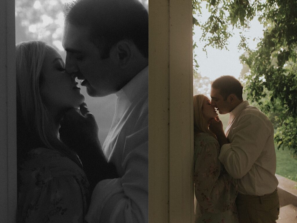 Man kisses his fiance up against a white post romantically with golden hour sun lit behind them. 