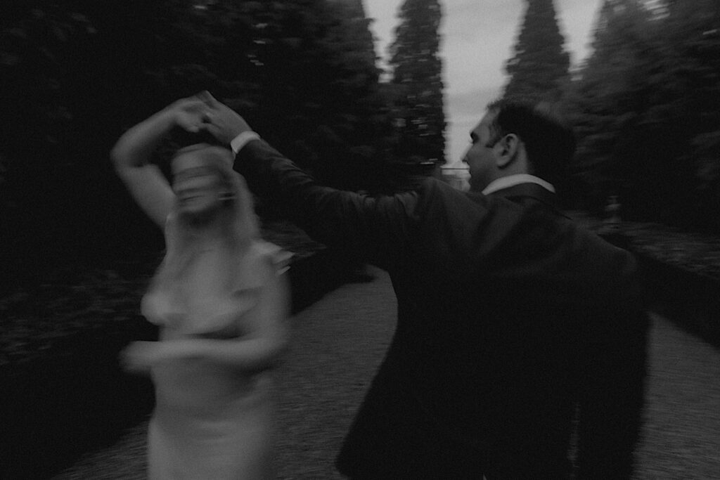 Illinois Engagement Photographer captures man spinning his fiancee in trending blurry aesthetic portrait in black and white. 