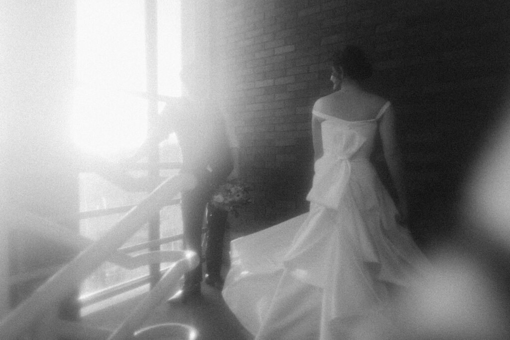 Central Illinois Wedding photographer captures fuzzy filmy portrait of bride and groom walking up steps of stairwell to the rooftop of Reality on Monroe in Central Illinois. 