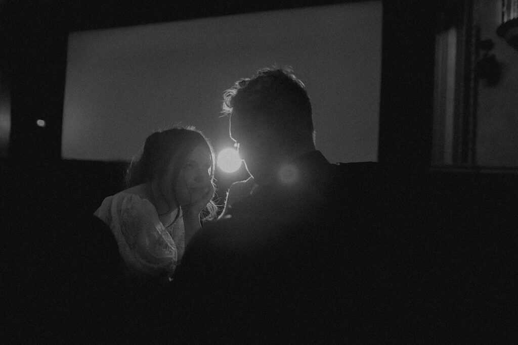 Black and white artful photo of a couple sitting together in the Virginia Theatre of Champaign, Illinois during their engagement photos