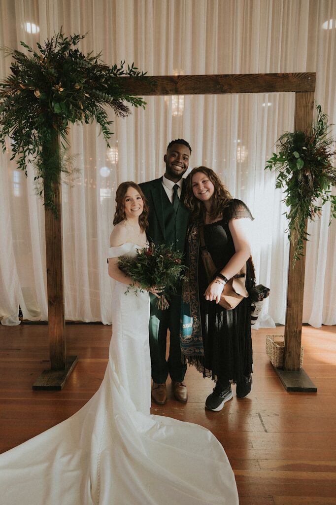 Rachael from Rachael Marie Photography takes a photo with her couple after their wedding ceremony at the Artisans Building in Springfield Illinois. 