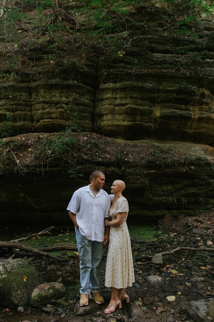 A couple stands holding one another during their engagement session in Matthiessen State Park in Central Illinois. 