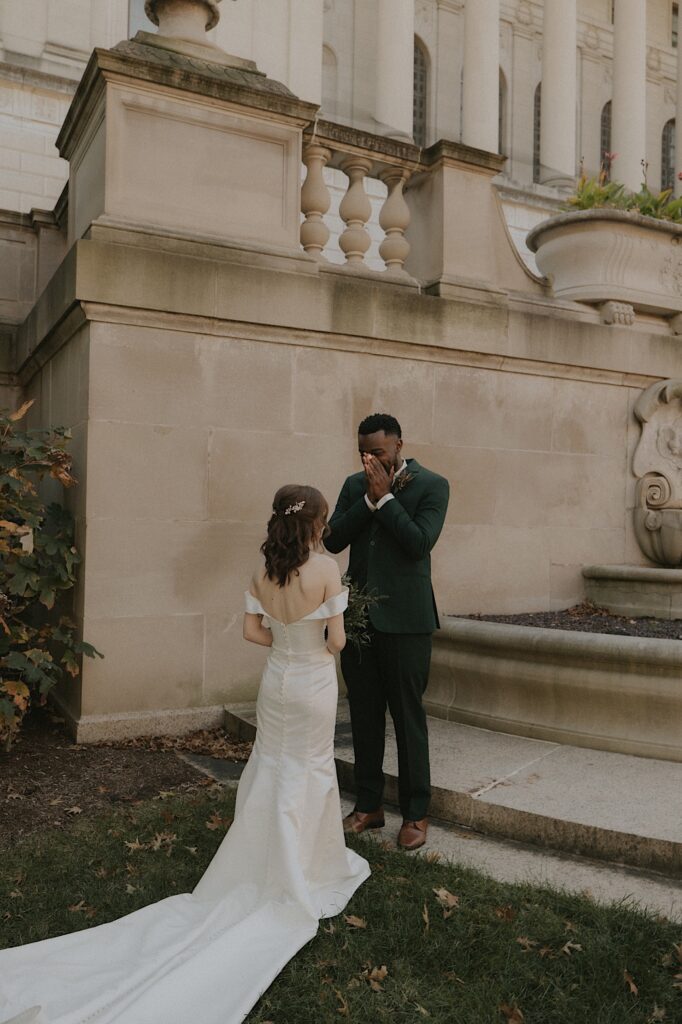 A groom sees his bride for the first time on their wedding day outside the Illinois State Capitol Building. 