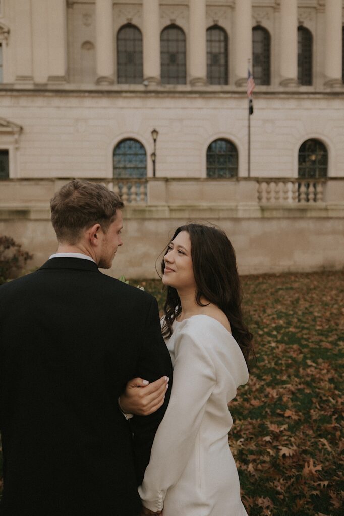 A couple stands outside the Illinois State Capitol in Sangamon County in the fall on their elopement day.