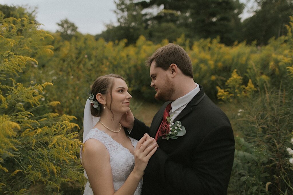 A married couple takes a moment on their wedding day surrounded by fall golden rod in Washington park. 