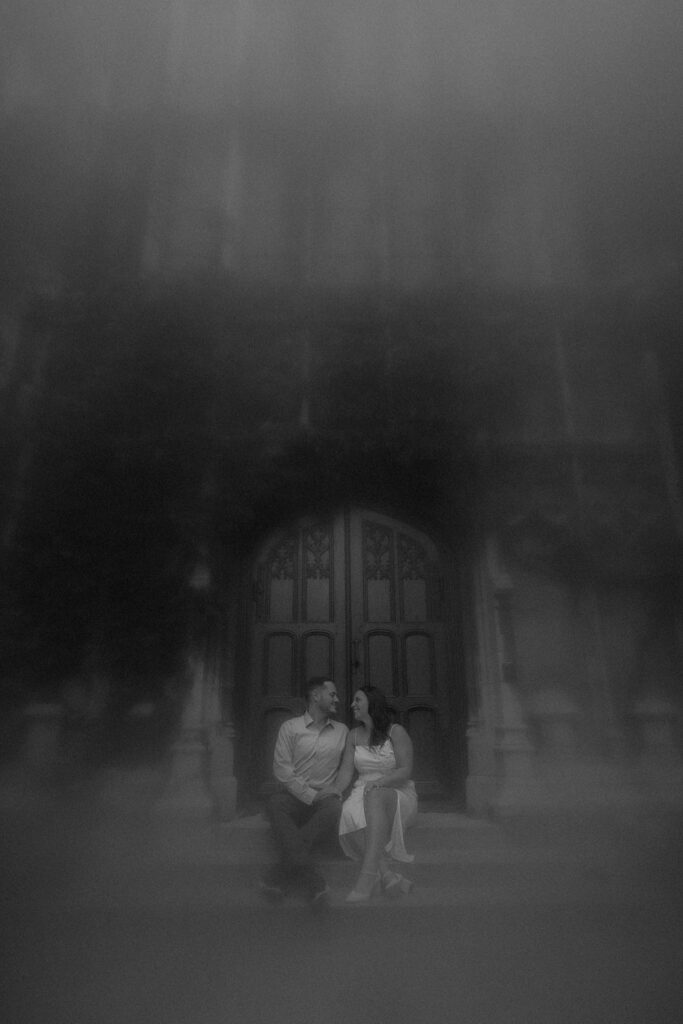 A couple sits on the chapel steps in front of the Church on University of Chicago's Campus. 